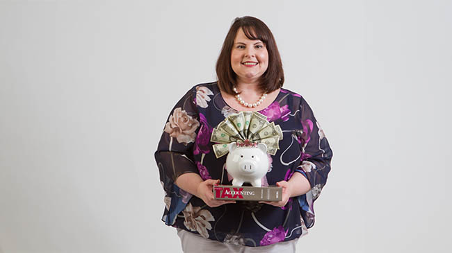 A woman holds a piggy bank and a book