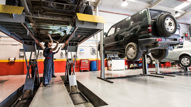 Mechanic fixing a car in a garage.