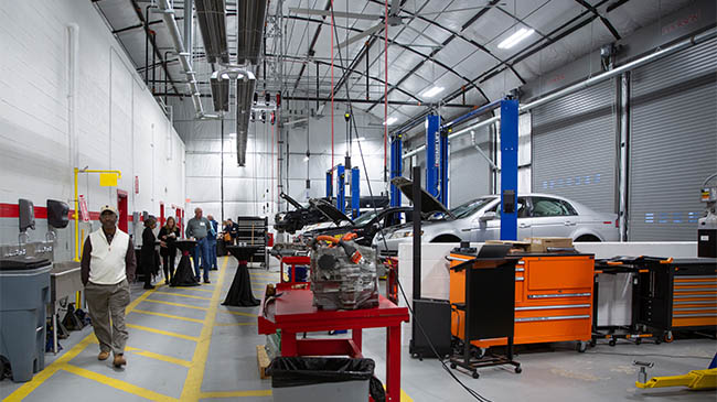 Reynolds automotive facility building, interior, line of cars on lifts with hoods up