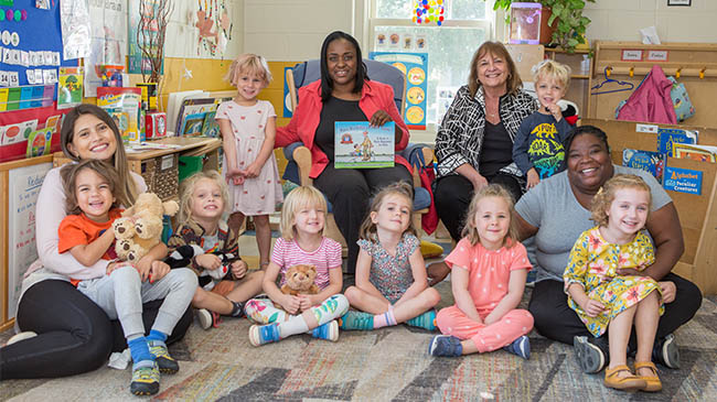 Children and teachers sitting together. 