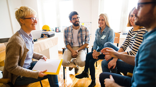 A group of individuals engaged in a lively conversation while seated around a table.