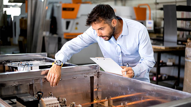 The engineer oversees the process of working in an electrical workshop